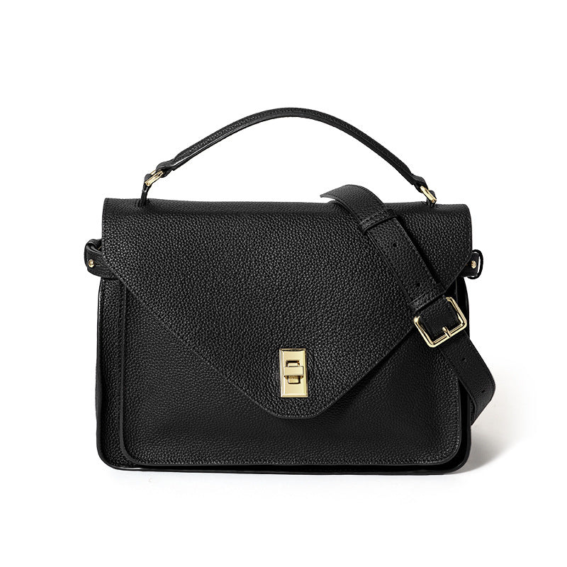 Black leather handbag with gold accents on a white background