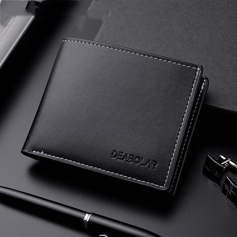 Black leather wallet with 'DEAGOU' branding on a dark surface with office items.