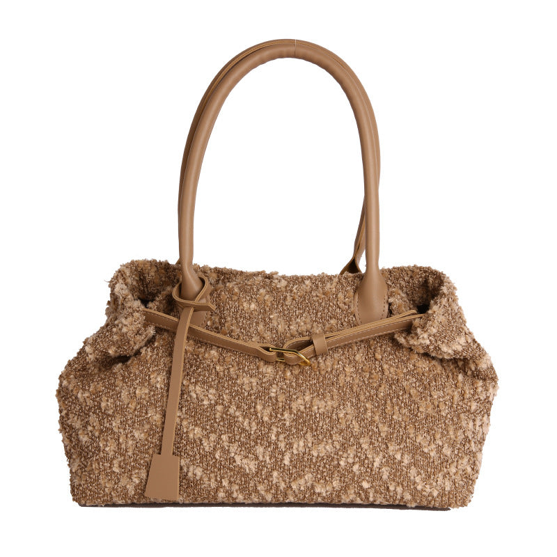 Brown textured handbag with a matching handle on a white background