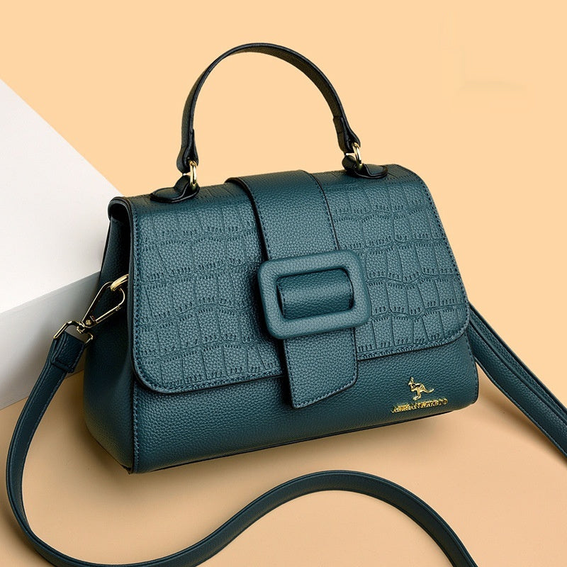 Green handbag with a strap on a beige background