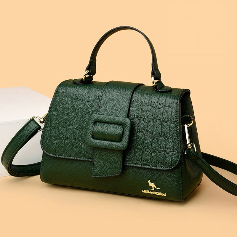 Green handbag with a textured pattern on a beige background