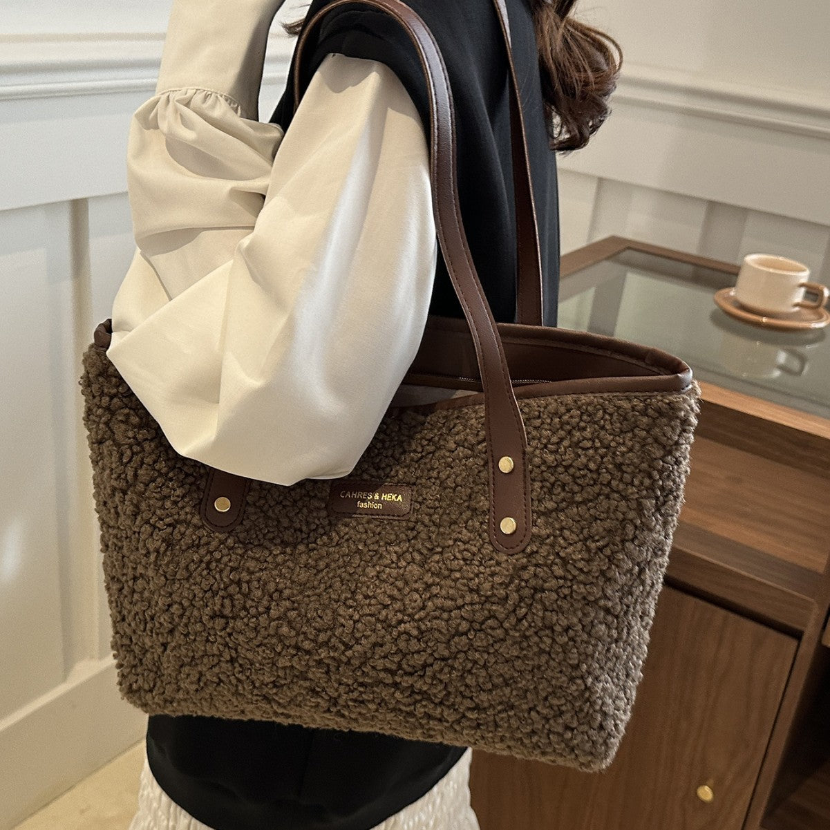 Brown textured handbag held by a person in a casual setting